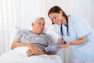 Nurse With Clipboard Visiting Senior Male