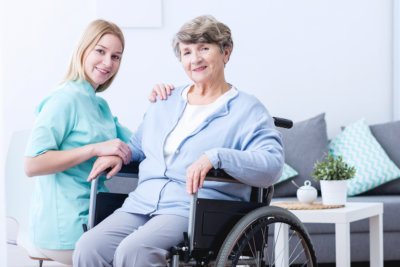 a female caregiver and an elderly woman sitting